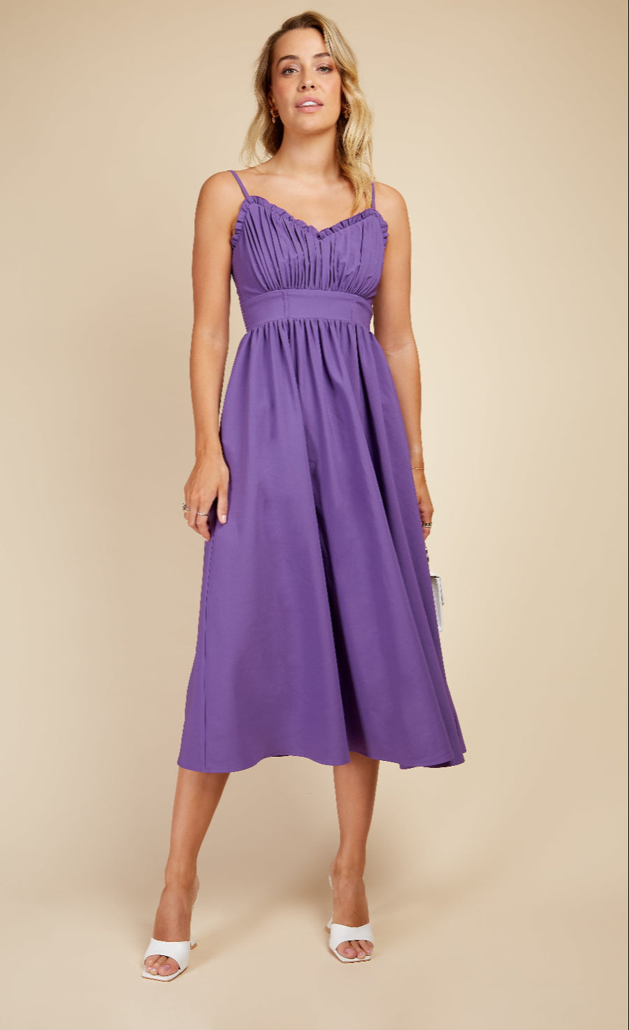 Woman wearing a purple dress against a beige background