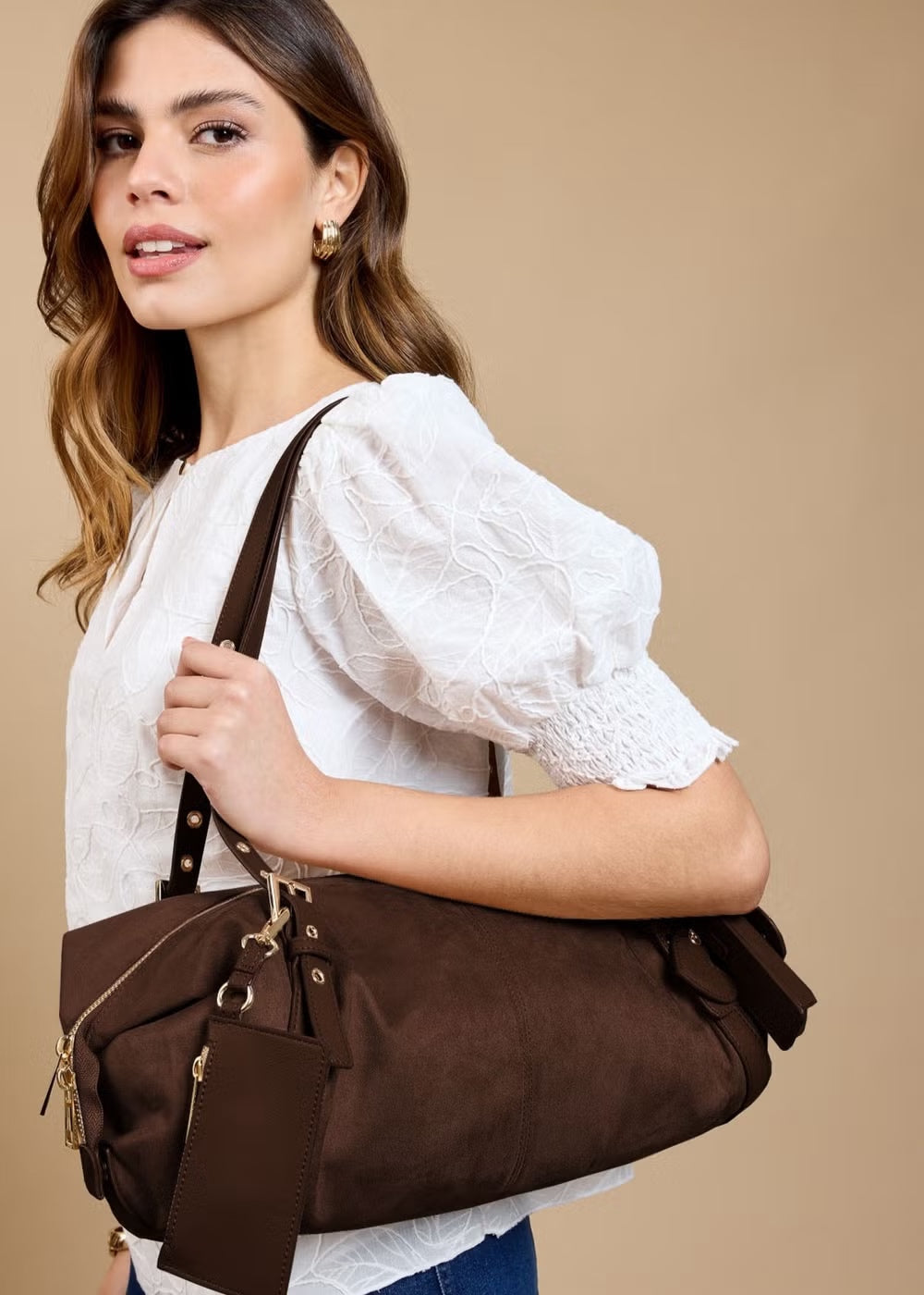 Model carrying a chocolate brown slouch shoulder bag
