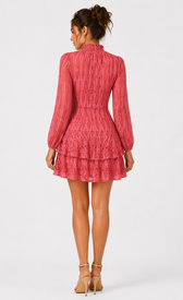 Back view of a trendy coral lace high neck mini dress with long sleeves and a tiered skirt.