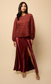 Mireille Cherry Sequin Eyelash Jumper paired with a satin skirt, showcasing a chic, cozy look with sparkle.
