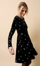 Sondra Black Velvet Embroidered Mini Dress modeled by woman, showcasing elegant design and intricate embroidery.