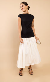 Amoura Monochrome Dropped Waist Maxi Dress styled with strappy heels and a handbag.