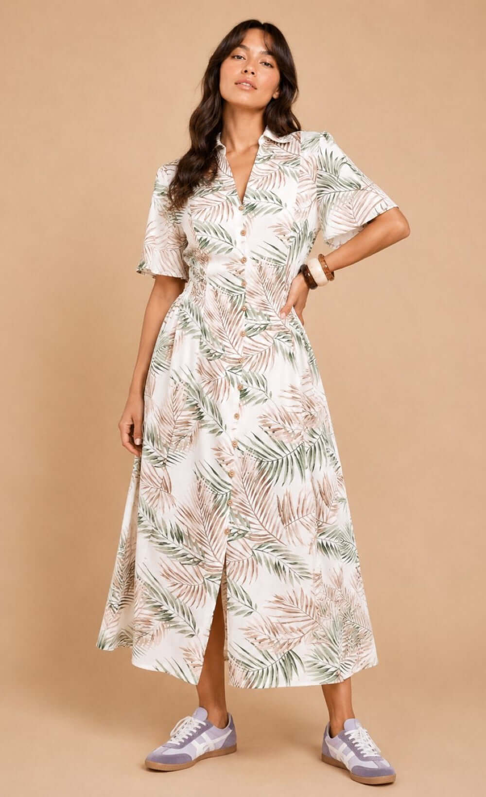 Trendy chic UK woman wearing a palm print midi dress with a button-down front, ideal for warm-weather occasions. Ref: D36083R1A.